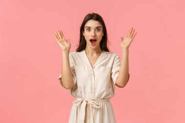 Vay canına, süper sürpriz. Şaşırmış ve merak etmiş, heyecanlı mutlu, mutlu, güzel beyaz elbiseli güzel kadın, ellerini kaldır hayrete düşmüş, ağzı açık ve kameraya bak heyecanlı, pembe arka plan