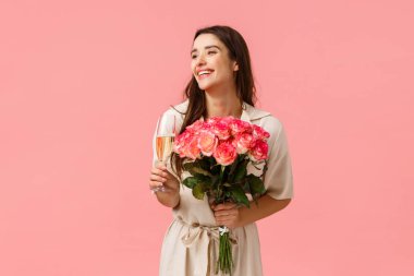 Zarafet, romantizm ve sevgililer günü konsepti. Kadın doğum gününü kutluyor, eğleniyor, eğleniyor, şampanya bardağı tutuyor, içiyor ve gülüyor, güzel çiçekler alıyor.