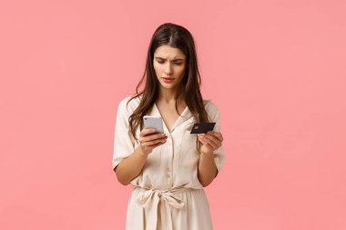 Teknoloji eklemesi, mobil yaşam tarzı konsepti. Karmaşık genç çekici kadın banka hesabının, hesap bakiyesinin, kredi kartının ve akıllı telefonun nerede olduğunu bilemiyor.
