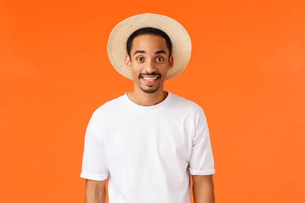 휴가 준비됐어요. 모자와 티셔츠를 입고 행복 한 미소짓는 아프리카 계 미국인 남자, 여행 긍정적 인 기분 마침내 바다에 의해 휴식을 즐기며, 오렌지 배경을 서서 여름을 즐길 — 스톡 사진