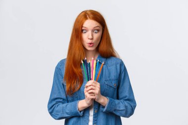 Kız hevesle yeni sanat kurslarına başlıyor, tasarım yapmayı öğreniyor, mankenler yapıyor, renkli kalemlerle ayakta duruyor, dudaklarını katlıyor, aletlere bakıyor merak ediyor ve heyecanlanıyor, beyaz arkaplanı çiziyor.