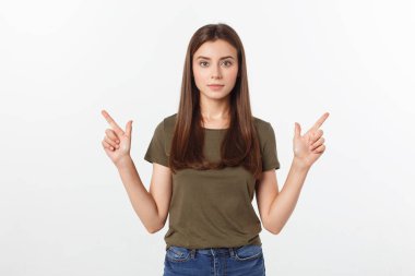 Gri arka planda yalnız duran mutlu ve şaşırmış genç bir bayan portresi. Kamera işaret ediyor.