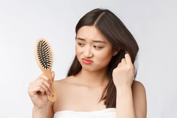 Kesal menekankan wanita muda Asia memegang rambut kering yang rusak di tangan atas putih terisolasi latar belakang . — Stok Foto