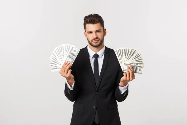 Retrato de un joven empresario satisfecho sosteniendo un montón de billetes de dinero aislados sobre fondo blanco . — Foto de Stock