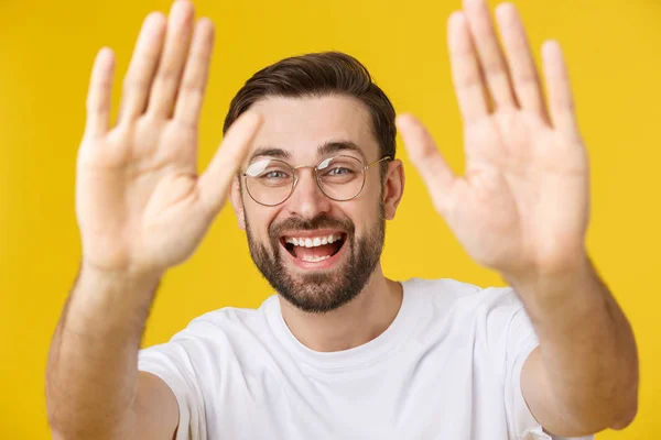 Hallo, hallo. Porträt eines glücklichen freundlichen, braunhaarigen Mannes mit kleinem Bart im weißen Hemd, der mit freundlichem Lächeln in die Kamera winkt. — Stockfoto