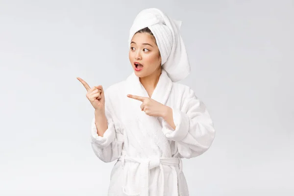 Retrato de beleza de jovem mostrando e apontando o dedo para espaço de cópia vazia, beleza asiática em roupão de banho . — Fotografia de Stock
