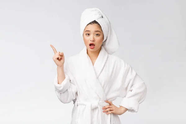 Retrato de belleza de mujer joven mostrando y señalando el dedo al espacio de copia vacío, belleza asiática en albornoz . —  Fotos de Stock