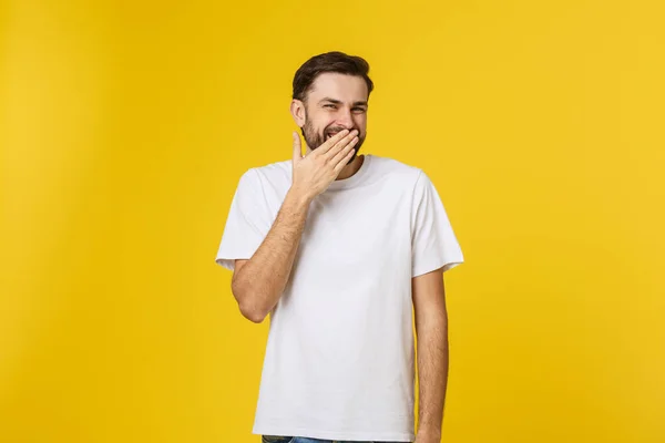Κοντινό πορτρέτο του νεαρού άνδρα που γελάει με το χέρι που καλύπτει το στόμα με κίτρινο φόντο — Φωτογραφία Αρχείου