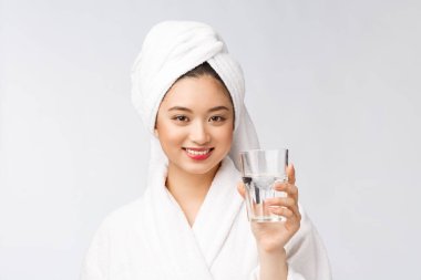 Sağlıklı, su içen genç, güzel bir kadın. Yüzü doğal makyajlı, beyaz arka planda soyutlanmış..