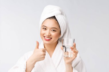 Sağlıklı, su içen genç, güzel bir kadın. Yüzü doğal makyajlı, beyaz arka planda soyutlanmış..