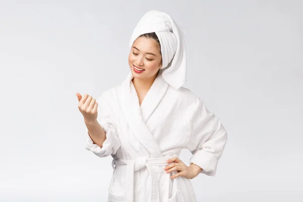 Skönhet asiatisk flicka som kontrollerar sin hud. hudvård. Isolerad över vit bakgrund. — Stockfoto