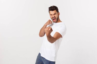 Çekici yakışıklı. Beyaz arka planda tek başına dikilirken sıradan giyinen yakışıklı genç adam.