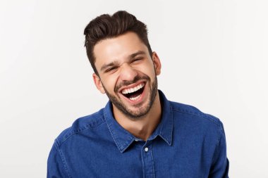 Çekici yakışıklı. Beyaz arka planda tek başına dikilirken sıradan giyinen yakışıklı genç adam.