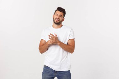 Hayal kırıklığına uğramış sakallı, beyaz arka planda tişörtlü bir gencin yakın portresi..