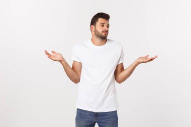 Hayal kırıklığına uğramış sakallı, beyaz arka planda tişörtlü bir gencin yakın portresi..