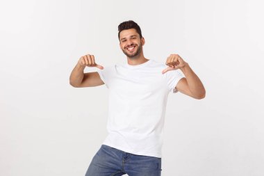 Çekici yakışıklı. Beyaz arka planda tek başına dikilirken sıradan giyinen yakışıklı genç adam.