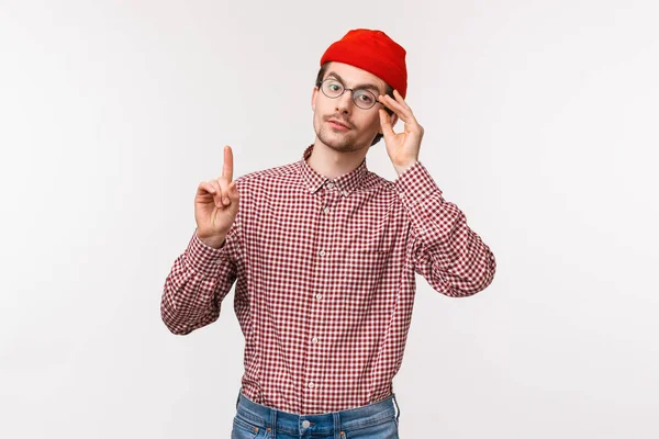 Cintura-up retrato de homem inteligente e esnobe patrocina alguém, repreendendo alguém ou pessoa correta, levantar um dedo adicionando sua opinião, fixando óculos no rosto, s tand fundo branco — Fotografia de Stock