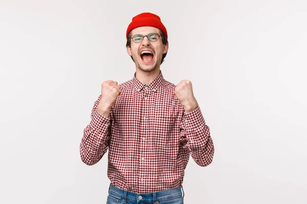 Retrato de feliz joven alegre colocado apuesta y ganar el premio, enraizamiento para el equipo viendo partido deportivo, gritando triunfante y bomba de puño como la celebración de la victoria, convertirse en campeón, fondo blanco — Foto de Stock