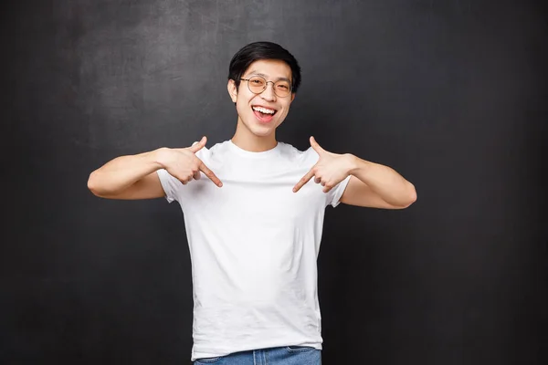 Retrato de alegre fresco amigable asiático chico apuntando en el enlace, indicar abajo hacia abajo anuncio, invitando a revisar algo impresionante, organizar la fiesta y pedir mirada, sonrisa cámara — Foto de Stock