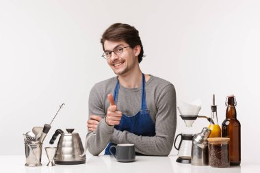 Barmen, kafe çalışanı ve barmen konsepti. Küstah beyaz erkek çalışanın portresi müşteriyi içmeye davet ediyor, kahve hazırlıyor, yeni gelenlere cappuccino yapmayı öğretiyor, beyaz arka plan