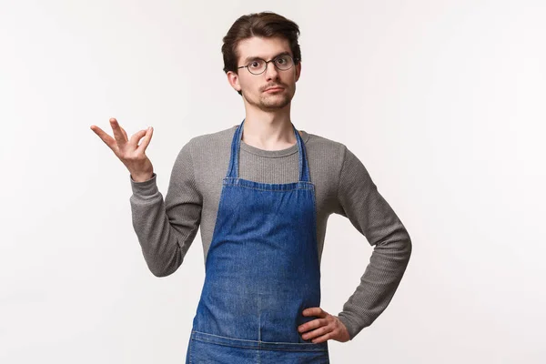 Portret van vastberaden en serieuze jonge knappe man gepassioneerd door koffie, praten over brouwen en smaken van drank, bespreken cafe business staan in schort en kijk camera besluiteloos — Stockfoto