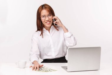 Kariyer, iş ve kadın girişimciler konsepti. Başarılı Asyalı zengin iş kadınının yakın plan portresi iyi bir anlaşma imzaladı. Bilgisayarlı, paralı, cep telefonlu bir ofiste oturuyor.