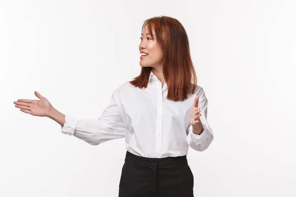 Retrato de joven profesional mujer empresaria asiática, señora jefa apuntando a la izquierda y a la cámara, mostrando el camino, sonriendo como introducir propio proyecto, hablando con el público, de pie fondo blanco — Foto de Stock