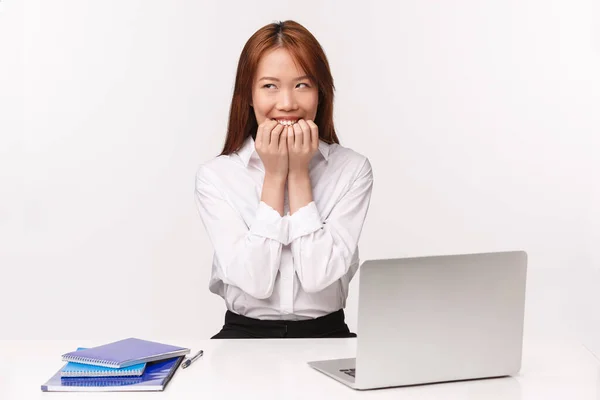 Conceito de carreira, trabalho e mulheres empresárias. retrato de sly e pensativo, dreamy bobo asiático menina sentado no escritório mesa com documentos e laptop, planejando ter interessante pensamento, riso — Fotografia de Stock