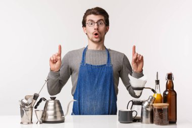 Barmen, kafe çalışanı ve barmen konsepti. Etkilenmiş ve heyecanlı çalışan, parmaklarını havaya kaldıran, sersemlemiş, kahve hazırlama hakkında konuşan, bar tezgahının yanında duran, beyaz arka plan.