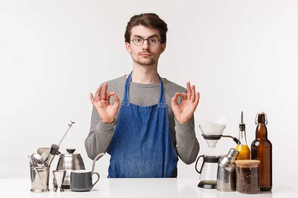 Barista, cafe worker and bartender concept. Portrait of serious-looking young caucasian guy in glasses and apron, show okay excellent sign, agree or guarantee customer will like coffee — Stock Photo, Image