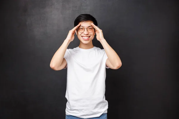 Feliz joven carismático se siente bien, mejoró después de haber recetado medicina, sonriendo cámara y tomados de la mano cerca de la frente como si viera algo a distancia, encontró el lugar perfecto — Foto de Stock