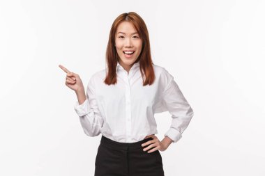 Beyaz gömlekli, etekli, solu gösteren ve kameraya tatmin olmuş bir şekilde gülümseyen başarılı bir Asyalı kadın portresi bulundu.