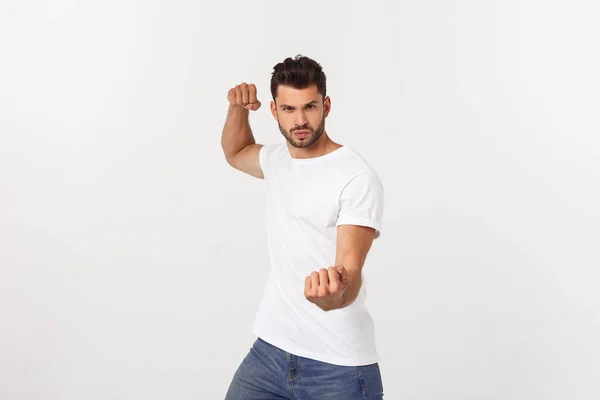 Joven hombre guapo sobre fondo aislado puñetazo puño para luchar, ataque agresivo y enojado, amenaza y violencia —  Fotos de Stock