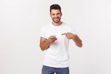 Gri arka planda akıllı telefondan oynayan mutlu sıradan bir adam.