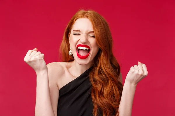 Célébration, émotions et concept de beauté. Gros plan portrait de jolie jeune femme rousse élégante se sentent comme champion, crier oui ou hourra avec les poings serrés, tirant, célébrant — Photo