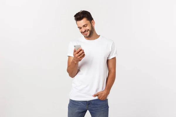 Feliz homem casual jogando no smartphone sobre fundo cinza — Fotografia de Stock