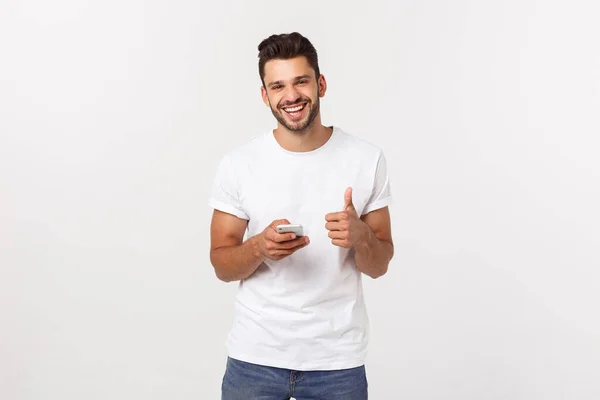 Akıllı telefonu ve gri arka planı olan mutlu sıradan bir adam.