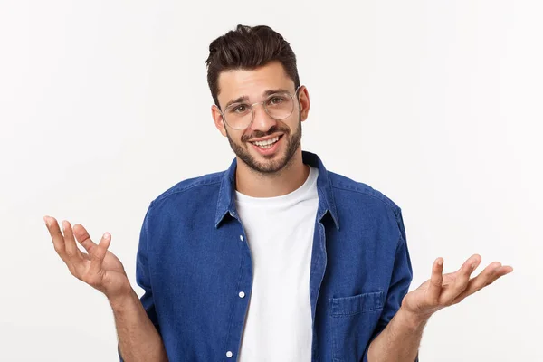 Bonito jovem empresário em terno clássico sorrindo, olhando para a câmera mantendo a palma da mão no fundo branco. Homem de negócios com a mão vazia . — Fotografia de Stock