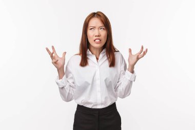 Asyalı kızgın kadın sinir bozucu müşterilerden nefret eder. Sıkıntılı ve gergin beyaz gömlekli bir kadın, yumrukları sıkan elleri sabrını yitirmiş yukarıya bakıyor, sıkıntıdan köpürüyor, beyaz arka plan