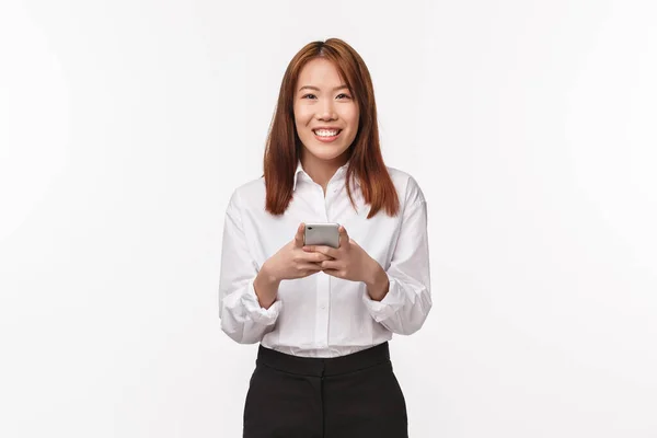 白シャツ、スカート、携帯電話を使用して休憩し、幸せな笑顔でカメラを見て、白の背景に成功し、陽気なアジアの女性のオフィスの労働者の肖像画 — ストック写真