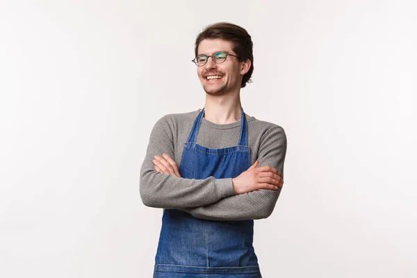 Carefree smiling young outgoing male bartender laughing with coworker standing in apron with hands crossed chest, look away delighted, manage own small business cafe, stand white background — Stock Photo, Image