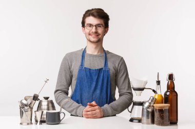 Barmen, kafe çalışanı ve barmen konsepti. Dost canlısı, güler yüzlü genç bir çalışan siparişinizi bekliyor. Bar tezgahında durup kahve yapan müşteriyi dinleyin. Beyaz arka plan.