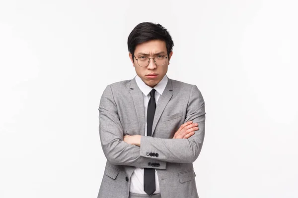 Waist-up portrait of offended and defensive young moody asian male office manager, clerk being upset with coworker prank, cross hands chest and look judgemental camera with pissed-off face — Stockfoto