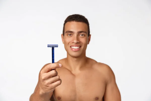 Close up de um homem africano nu feliz segurando navalha isolada sobre fundo cinza . — Fotografia de Stock