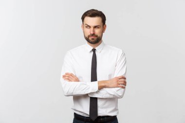 Beyaz arka planda çapraz kolları olan kendinden emin genç bir iş adamının portresi.