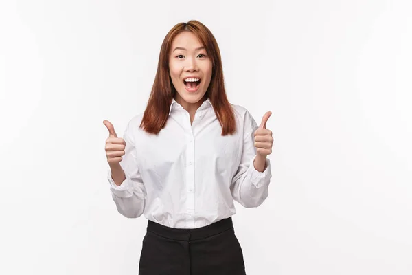 Good job, nice work team. Cheerful enthusiastic female entrepreneur, successful asian woman show thumbs-up and smiling with approval, agree give positive reply, recommend product