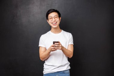 Teknoloji, aletler ve insan konsepti. Cep telefonu uygulaması kullanarak sipariş ettiği çiçek teslimatlı, neşeli, genç bir erkek sürpriz kız arkadaş.