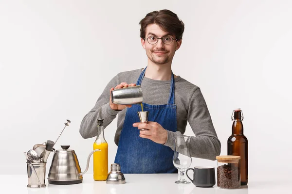 Barista, trabajador de cafetería y camarero concepto. Retrato de entusiasta joven y feliz empleado en delantal, haciendo café, sirviendo bebida en la coctelera, mezclando sabores, de pie fondo blanco — Foto de Stock