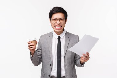 Office workers, business and lifestyle concept. Waist-up portrait of pissed-off angry asian businessman aggressive grimace, scolding employee for bad report, holding document and coffee