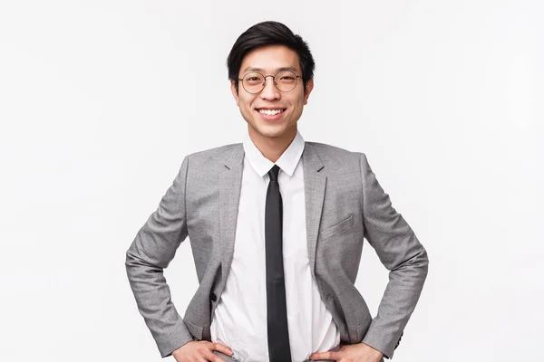 Låt oss tjäna lite pengar. Snygg självsäker och smart asiatisk affärsman i kostym och slips, står i redo, beslutsam pose, ler optimism, försäkrade att han kommer att få affären, vit bakgrund — Stockfoto